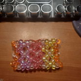 transparent kandi cuff made out of pink, purple, orange, 
    and yellow beads
